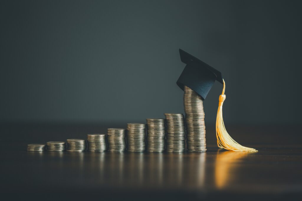 financial education image of a graduation cap on bar graph of coins